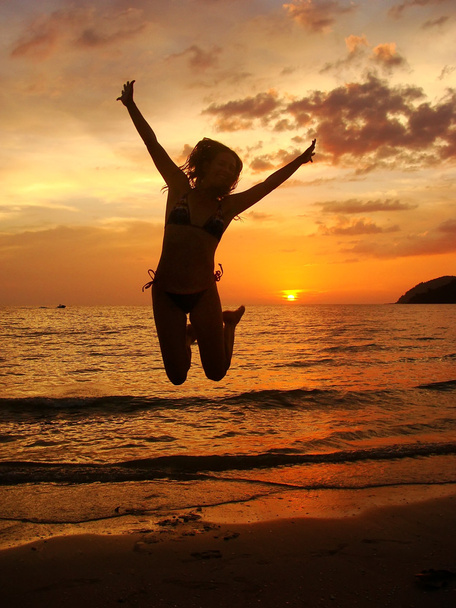silhouet van jonge vrouw springen op zonsondergang, langkawi island, ma - Foto, afbeelding
