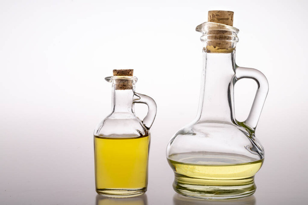 Oil in glass containers. Household oil jugs. Light background. - Фото, изображение