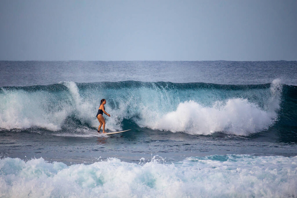 Hikkaduwa, Sri Lanka - 15 / 12 / 2019 - Chica surfista profesional montando algunas olas  - Foto, imagen
