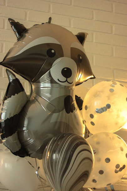Helium schwarze und weiße Luftballons zum Geburtstag, eine riesige Kugel in Form eines Waschbären. Glückwunsch zum Urlaub. - Foto, Bild