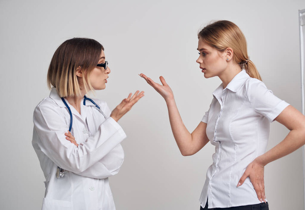 επαγγελματίας γιατρός με στηθοσκόπιο που εξηγεί κάτι σε ασθενή με μπλουζάκι - Φωτογραφία, εικόνα