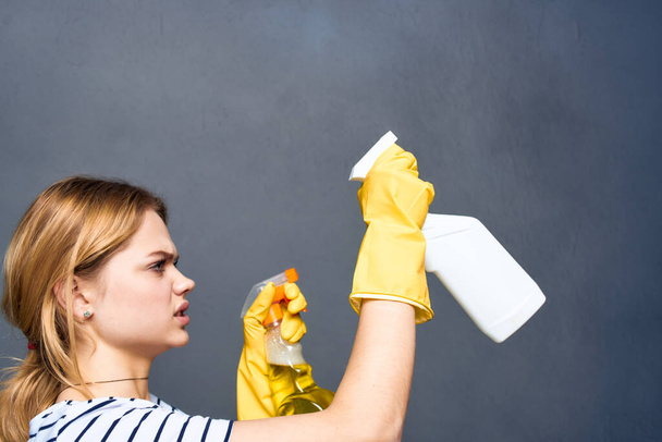 Cleaning lady in yellow rubber gloves detergents home care gray background - Фото, зображення