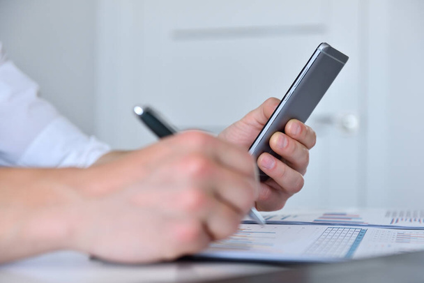 Accountant checks business report on smartphone. Business and financial success concept. Close up - Fotó, kép