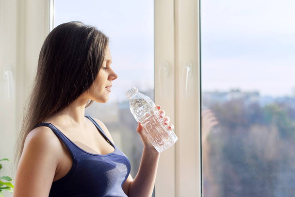 Young beautiful pregnant woman drinking water from bottle - Foto, Imagen