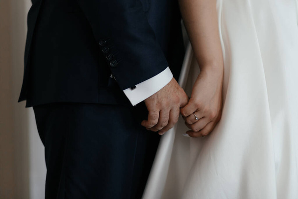 Nevěsta drží svého snoubence za ruku. Zblízka pár rukou. Zamilovaný pár - Fotografie, Obrázek