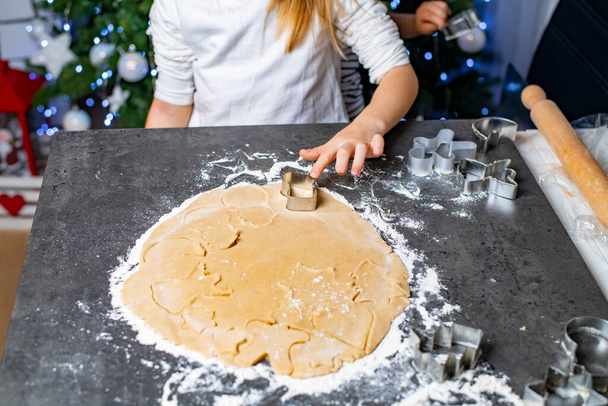 karácsonyi és újévi ünnepek, anya és a gyerekek mézeskalács sütiket készítenek - Fotó, kép