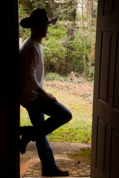 cowboy relaxing in a doorway - Foto, Imagen
