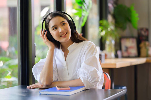 young smiling woman relaxing and listening to music with headphones - Photo, Image