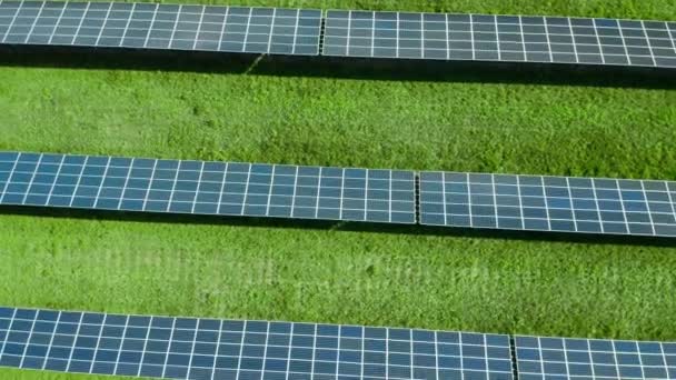 Levegő kering a napelemek felett a zöld mezőn. Fotovoltaikus erőmű - Felvétel, videó