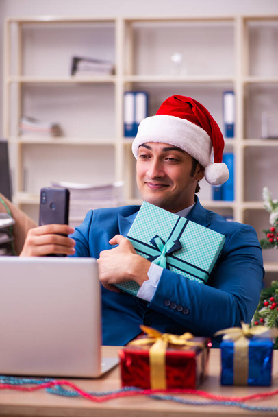 Young male employee celebrating Christmas at workplace - Photo, image