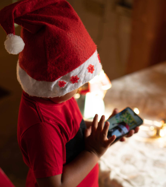 ラテン系の少年がクリスマスにビデオ通話をすると. - 写真・画像