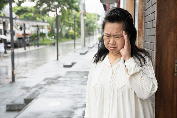 gestresste, depressieve Aziatische senior vrouw die last heeft van hoofdpijn - Foto, afbeelding