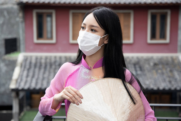 Молода в "єтнамка, одягнена в маску на відкритому повітрі. - Фото, зображення