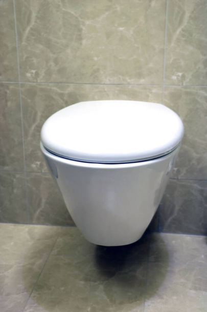 現代的なトイレの部屋の中には、便器、トイレブラシ、フラッシュボタンがあります。 - 写真・画像