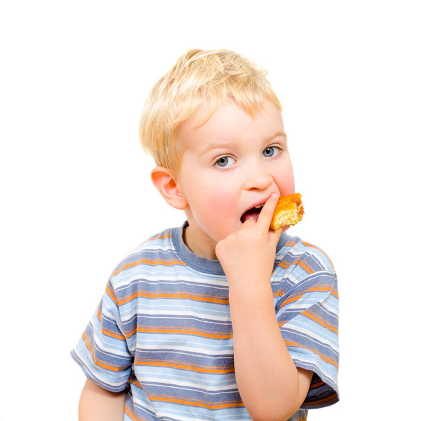 Mignon petit garçon manger délicieux cookie isolé sur blanc
 - Photo, image