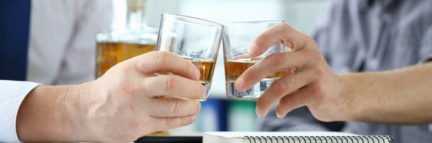 Άνδρες με κοστούμια πίνουν αλκοόλ στο χώρο εργασίας στο γραφείο - Φωτογραφία, εικόνα