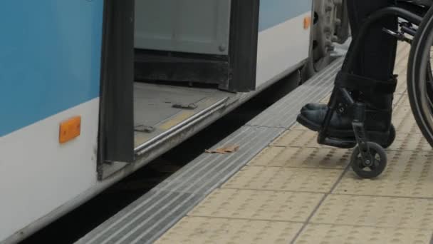 Vrouw in rolstoel bij een bushalte komt in de bus - Video