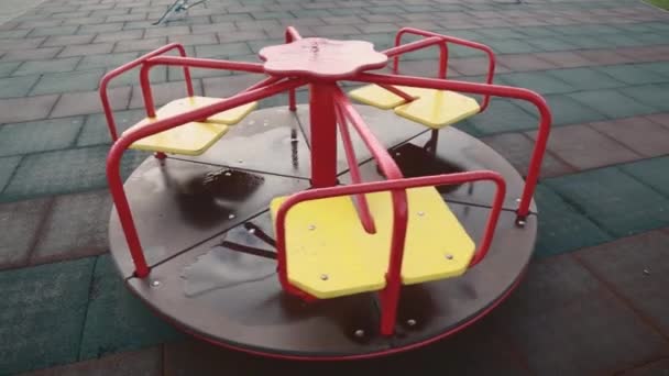 Childrens carousel turns without children after the rain. - Footage, Video