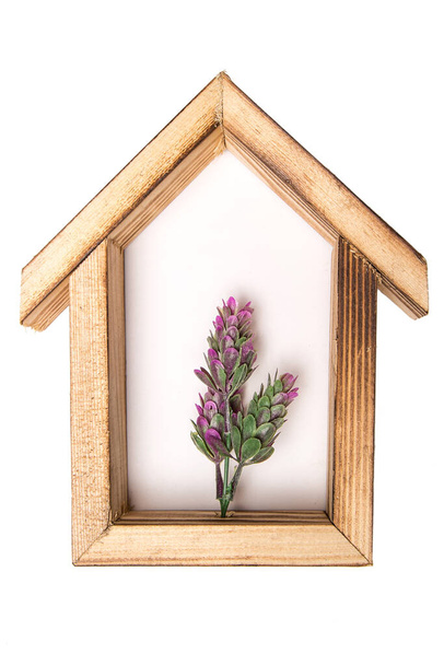 houten zeshoekige muur decoratieve frame met een kunstmatige bloem in het midden. op een witte geïsoleerde achtergrond. - Foto, afbeelding