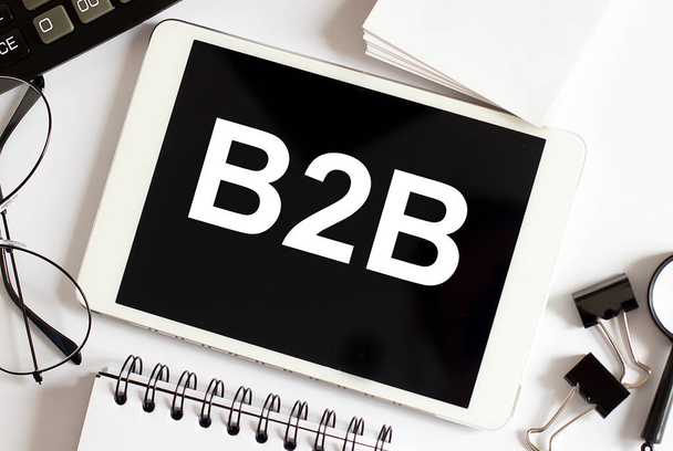 B2B Business Concept na bílém pozadí s kancelářskými nástroji - Fotografie, Obrázek