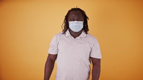 Afričan černošky muž s lékařskou maskou a copánkové vlasy ukazující finget směrem k fotoaparátu - Záběry, video