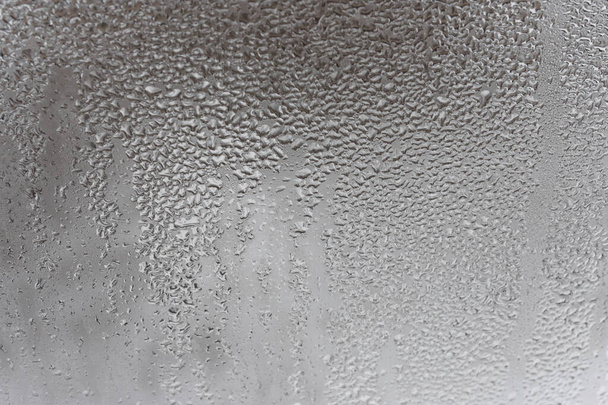Cierre para el vidrio empañado con gotitas de agua que drenan hacia abajo. Condensación por goteo, gotas de agua fondo Textura de condensación de gota de lluvia - Foto, imagen