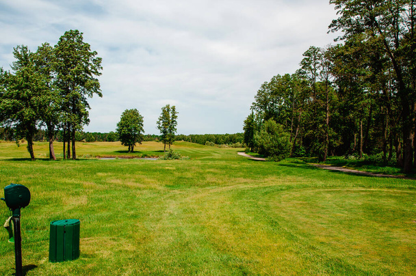 зеленое поле для гольфа и голубое облачное небо. Европейский ландшафт - Фото, изображение