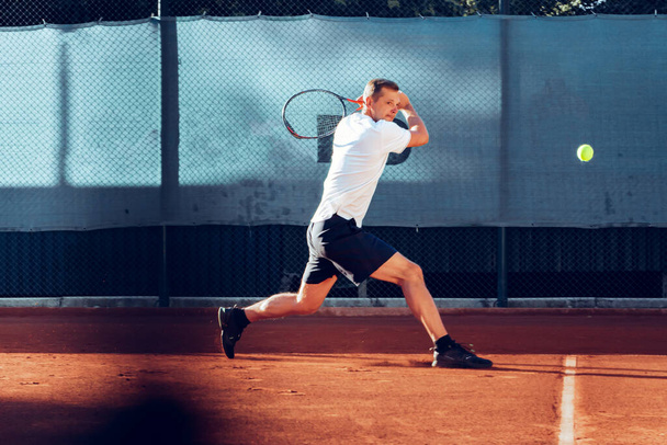Proffesional tennis player beats off a ball during match - Фото, зображення