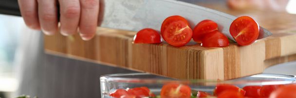 Κοντινό πλάνο του αρσενικού χεριού που προσθέτει ντομάτες στη σαλάτα - Φωτογραφία, εικόνα