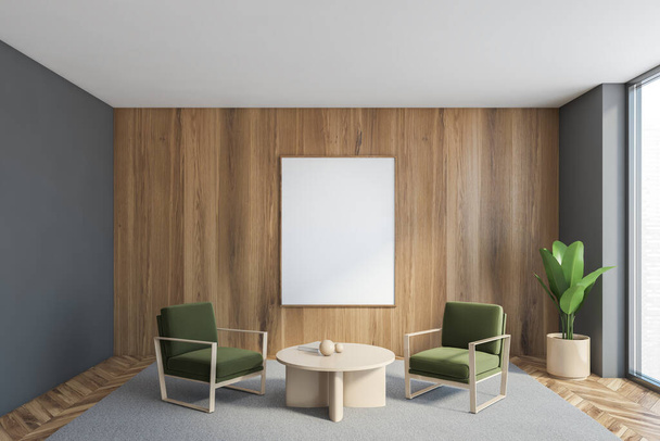 Mockup canvas frame on wooden wall in grey living room with two green armchairs and beige coffee table on grey carpet. Plant in the corner near big window, 3D rendering no people - 写真・画像