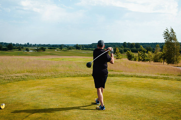 Αρσενικό παίκτη γκολφ σε επαγγελματικό γήπεδο γκολφ. Γκόλφερ με μπαστούνι του γκολφ. - Φωτογραφία, εικόνα
