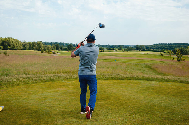 Jugador de golf masculino en campo de golf profesional. Golfista con palo de golf tomando un tiro - Foto, imagen