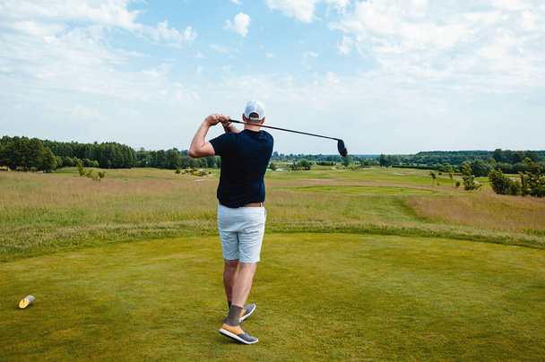 Чоловічий гравець в гольф на професійному полі для гольфу. Голфер з ключкою для гольфу. - Фото, зображення