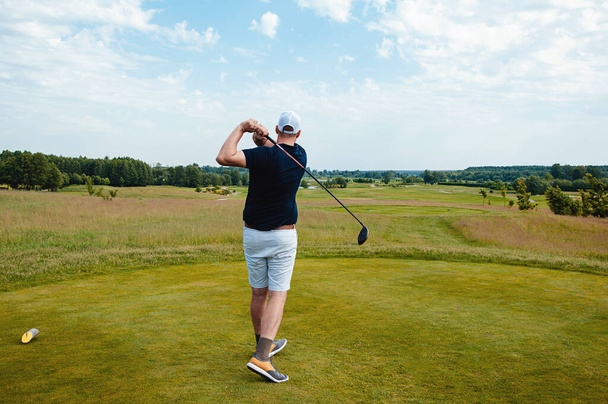 Männlicher Golfspieler auf einem professionellen Golfplatz. Golfer mit Golfschläger beim Abschlag - Foto, Bild
