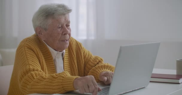 Oude vrouw praat met haar kleindochter op video bellen met behulp van een laptop.Video conferentie met een arts - Video