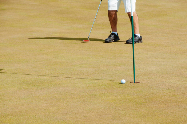 Male golf player on professional golf course. Golfer with golf club taking a shot - Photo, Image
