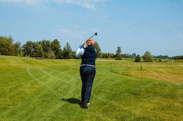 女子ゴルフ選手はゴルフコースでボールを打つ. - 写真・画像