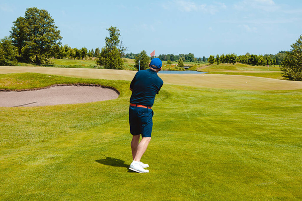 Чоловічий гравець в гольф на професійному полі для гольфу. Голфер з ключкою для гольфу. - Фото, зображення