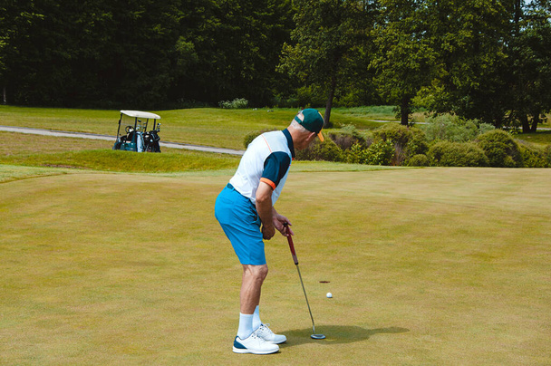 Männlicher Golfspieler auf einem professionellen Golfplatz. Golfer mit Golfschläger beim Abschlag - Foto, Bild