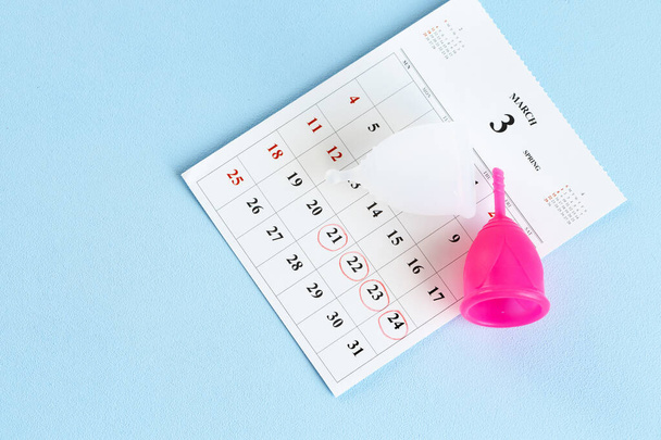 Calendar page and menstrual cup close up - Fotoğraf, Görsel