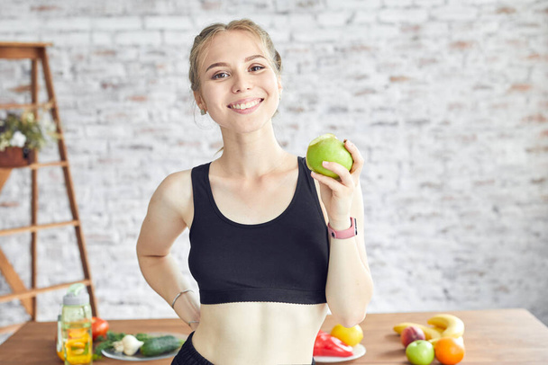 Sportive woman holding tasty apple. Concept of healthy organic and vitamin food. - Foto, Imagen
