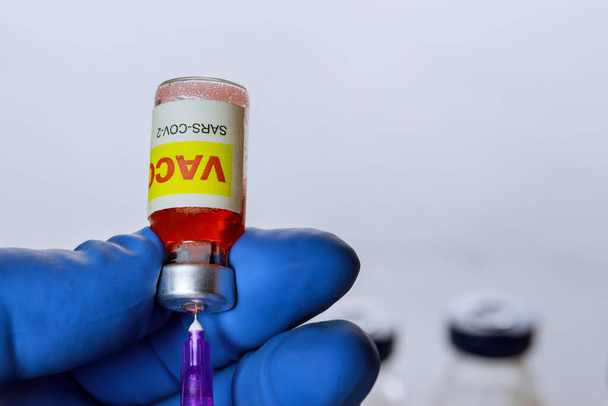 Ο γιατρός κάνει μια ένεση θεραπείας ένα εμβόλιο για τον κορωναϊό για την καταπολέμηση του εμβολίου πανδημίας του κορωναϊού COVID-19 SARS-COV- 2 - Φωτογραφία, εικόνα