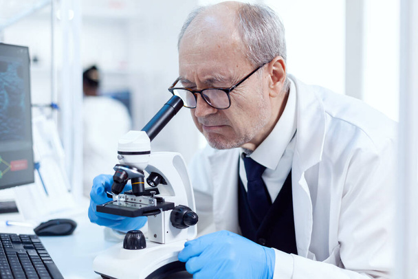Senior scientist working on busy laboratory - Photo, Image