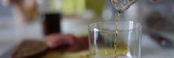 La mano femenina vierte bebida de licor en el vaso - Foto, Imagen