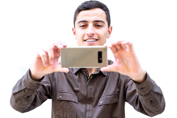 Арабський хлопець, який самовіддано користується своїм розумним телефоном - Фото, зображення