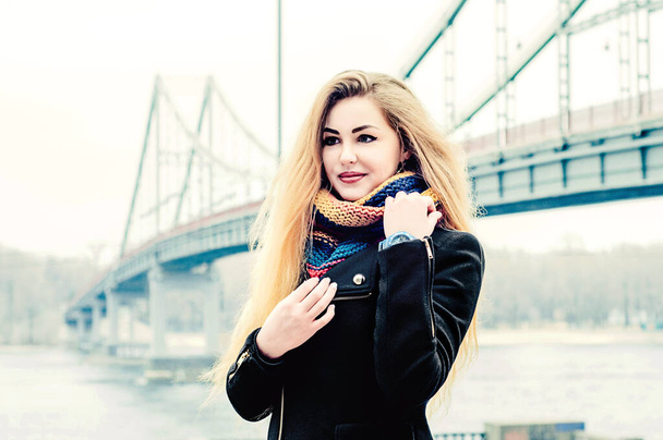 Емоційна молода блондинка на фоні мосту
. - Фото, зображення