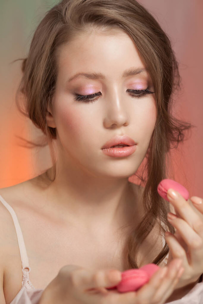 Beauty fashion model woman with delicate makeup and manicure taking pink macaroons - Foto, Bild