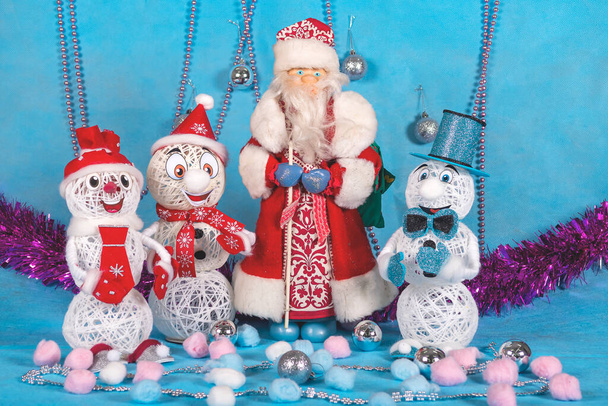 Три веселых снеговика стоят рядом с Санта-Клаусом и готовы праздновать Новый год - Фото, изображение