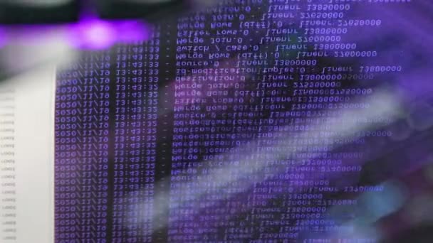 Violette computersoftware code beweegt op een zwarte monitor reflecteert op glas. Abstract computer hacken in proces met rack server base, dynamische tekst draait en stroomt op pc scherm. - Video