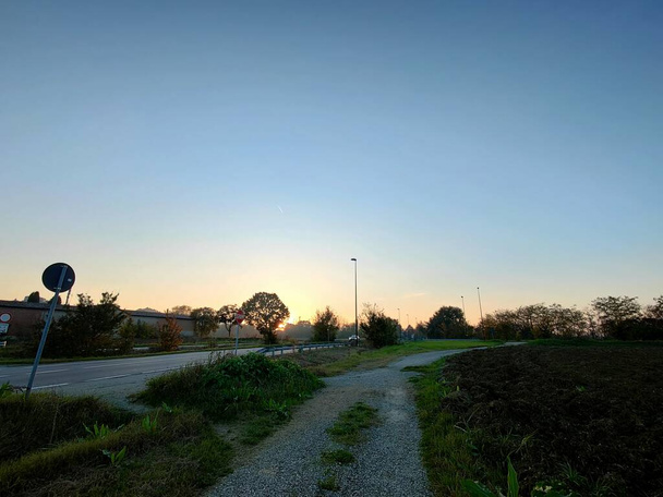 Гравійна дорога, яка пролягає біля брукованої дороги між полями пагорбів Кватро Кастелла в сутінках, Італія. Фотографія високої якості - Фото, зображення